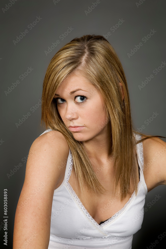 Teenage girl posing on gray background with some attitude Teenage girl posing on gray background with some attitude
