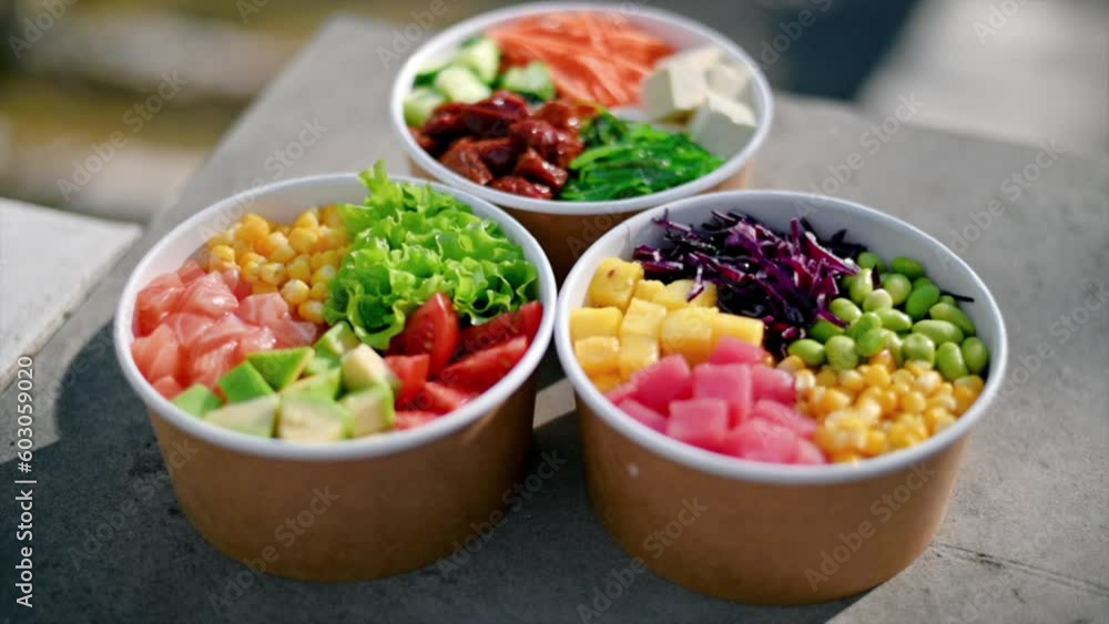 Close view of three poke bowls with vegetables, fruits, fish and seaweed salad Close view of three poke bowls with vegetables, fruits, fish and seaweed salad