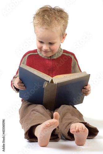 5 year old reading a book, isolated on white. Book is an old children's Bible.