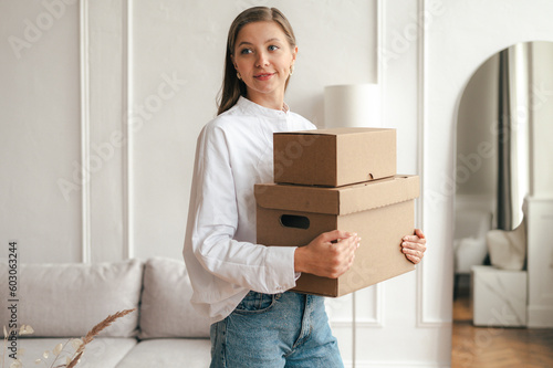 Calm woman with carton boxes in living room photo