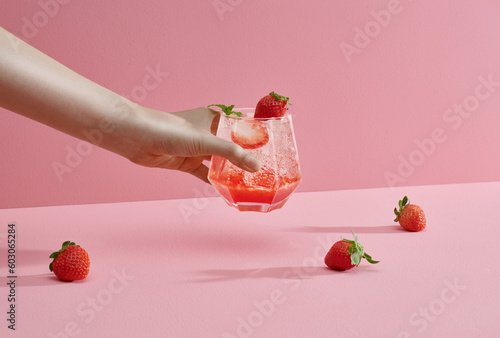Young woman hands holding freshly squeezed strawberry lemonade photo