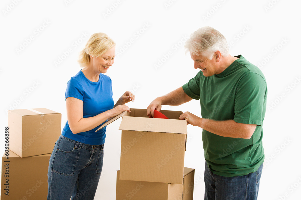 Middle-aged couple packing or unpacking moving boxes. Middle-aged couple packing or unpacking moving boxes.