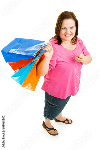 Pretty plus-sized woman shopping and listening to music on her mp3 player.  Full body isolated on white.