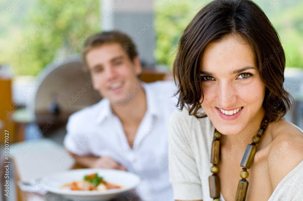 A young couple on vacation eating lunch at a relaxed outdoor restaurant A young couple on vacation eating lunch at a relaxed outdoor restaurant