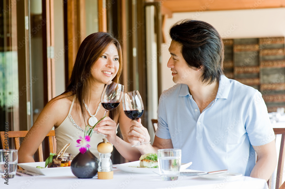 A young Asian couple having dinner at a restaurant A young Asian couple having dinner at a restaurant