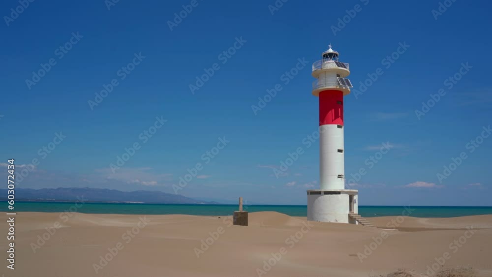 Lighthouse in Fangar Beach in Delta del Ebro in a sunny day with Mediterranean Sea in the background Lighthouse in Fangar Beach in Delta del Ebro in a sunny day with Mediterranean Sea in the background