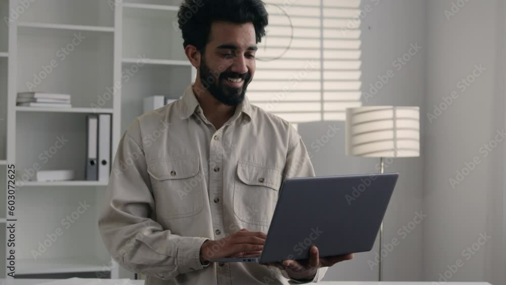 Muslim Indian man businessman working from home office remote job smiling Arabian bearded guy 30s freelancer stand with laptop typing business project chatting online studying happy male worker smile Muslim Indian man businessman working from home office remote job smiling Arabian bearded guy 30s freelancer stand with laptop typing business project chatting online studying happy male worker smile