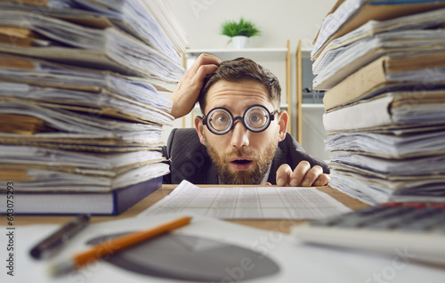 Obraz na płótnie Funny overwhelmed employee overloaded with paperwork in office