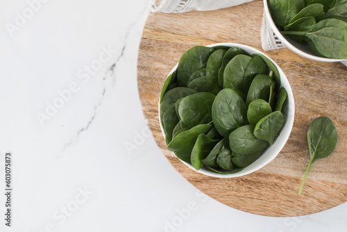 Fresh baby raw spinach on a plate. Copy space. Healthy eating.
