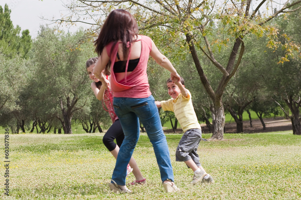 Back shot of a family playingin the park,outdoor Back shot of a family playingin the park,outdoor