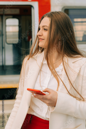 Woman smiline and looking away with a phone in her hands photo