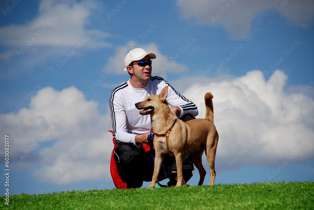 athletic man relaxing outdoors with his dog