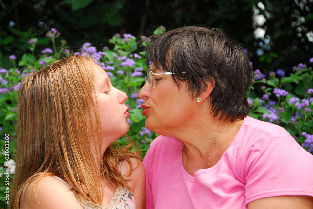 Portrait of grandmother and granddaughter in a garden Portrait of grandmother and granddaughter in a garden