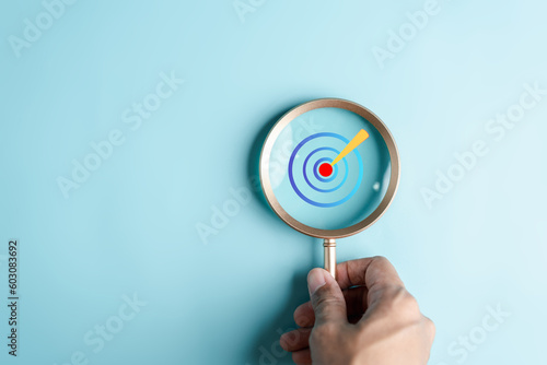 Magnifier glass focus to aiming target objective icon for planning development leadership and customer target group concept. © Kiattisak