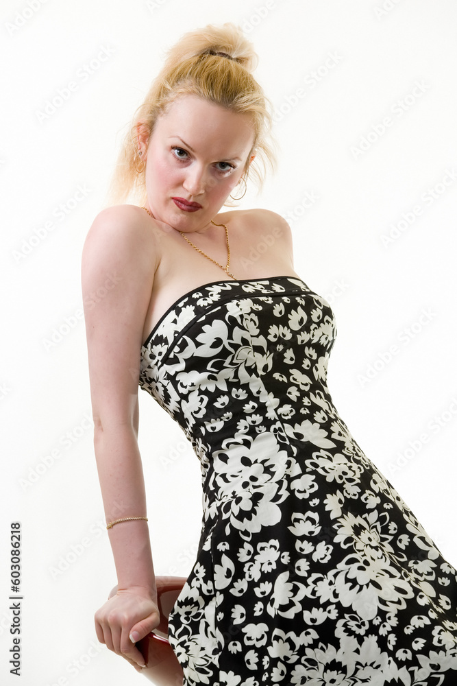 Full body of a blond woman wearing a party dress sitting on a stool Full body of a blond woman wearing a party dress sitting on a stool