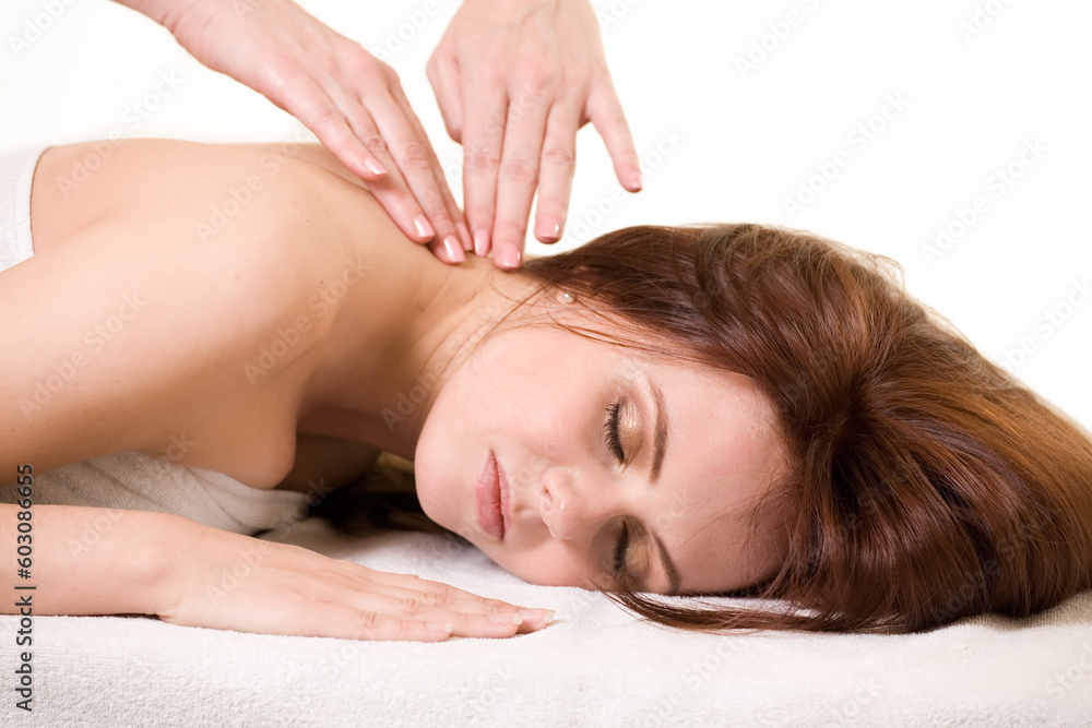 Attractive auburn haired woman laying on stomach with a relaxed expression showing hands of another woman giving a massage Attractive auburn haired woman laying on stomach with a relaxed expression showing hands of another woman giving a massage