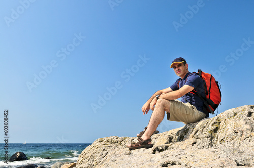 Middle aged hiker sitting on a rock