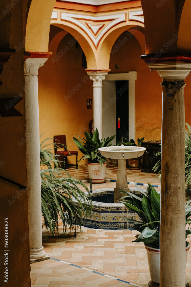 Andalusian archway in vibrant colored patio with tiled Fountain