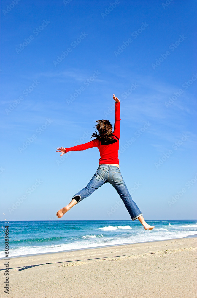 Young woman jumping on the beach and having fun Young woman jumping on the beach and having fun