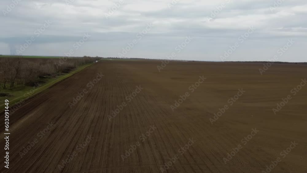 Blue tractor with yellow seeder working on the field in Ukraine OA Blue tractor with yellow seeder working on the field in Ukraine OA