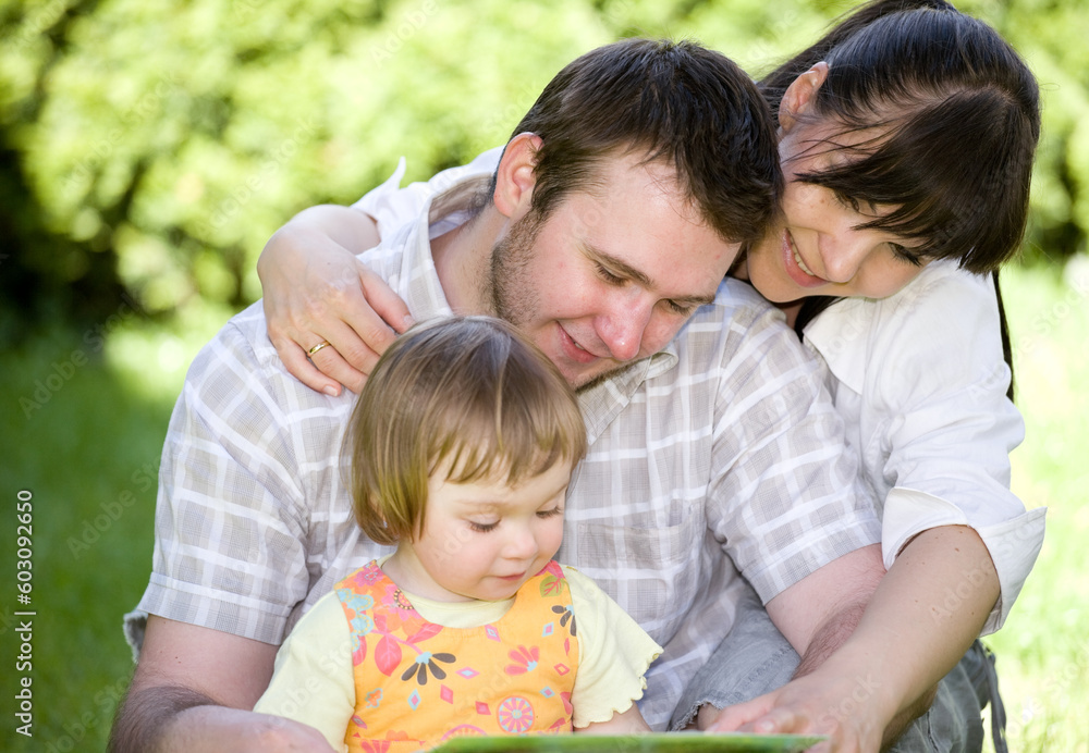 mother, father and daughter relaxing together on grass mother, father and daughter relaxing together on grass