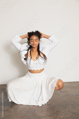 Beautiful black woman wearing long skirt and crouching down