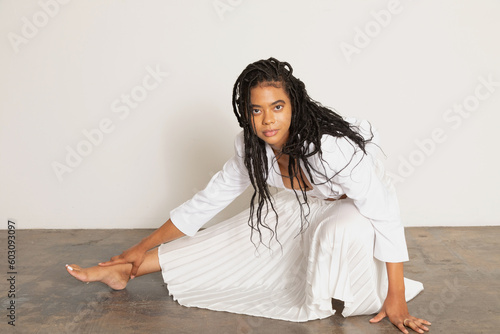Beautiful black woman crouching confidently in a long skirt