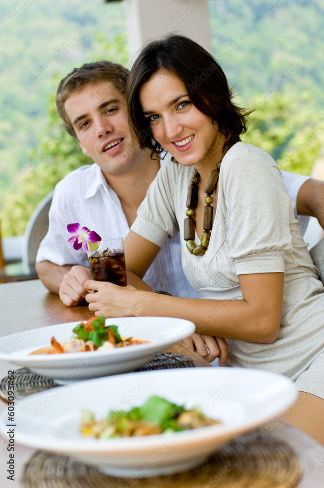 A young couple on vacation eating lunch at a relaxed outdoor restaurant A young couple on vacation eating lunch at a relaxed outdoor restaurant