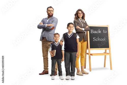 Full length portrait of schoolchildren posing with their teachers next to a blackboard