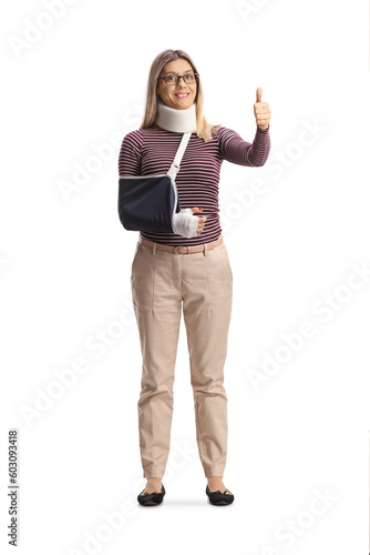 Full length portrait of a young injured woman with arm sling and cervical collar gesturing thumbs up