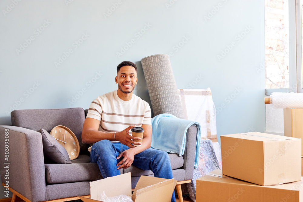 Smiling African American man looking at camera in room full of boxes Smiling African American man looking at camera in room full of boxes
