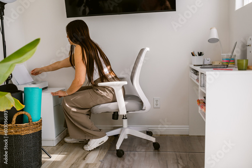 Freelance worker prints documents from her home office photo