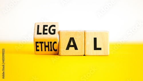 Ethical or legal symbol. Businessman turns wooden cubes and changes the word Ethical to Legal on a Beautiful yellow table white background. Business and ethical or legal concept. Copy space.