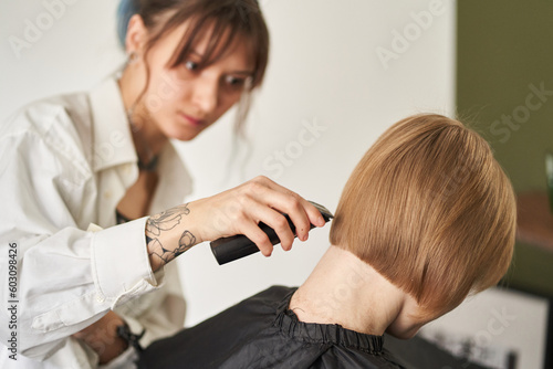 Hairdresser doing haircut to client in salon