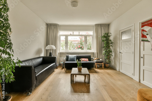 a living room with two couches  a coffee table and a plant on the floor in front of the window