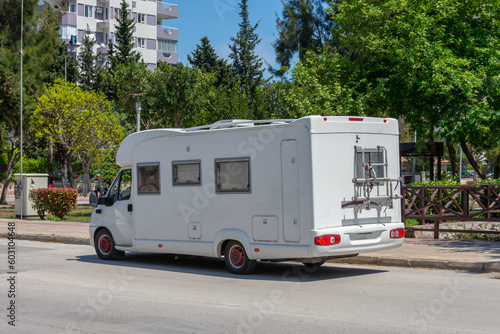 Mobile home on wheels van parked in the street of the city on the side of the road.