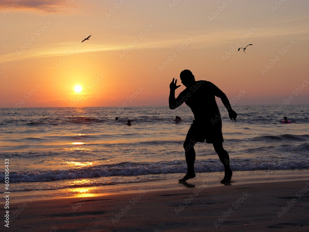 Man silhouette on the beach at sunset Man silhouette on the beach at sunset