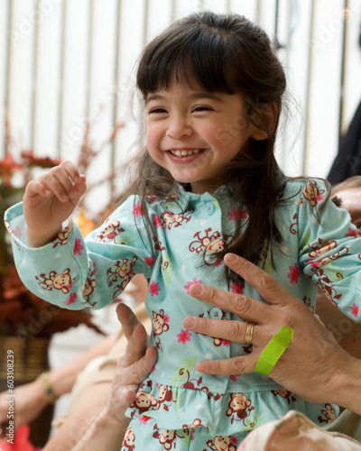 Adorable little three year old brunette girl in pyjamas laughing