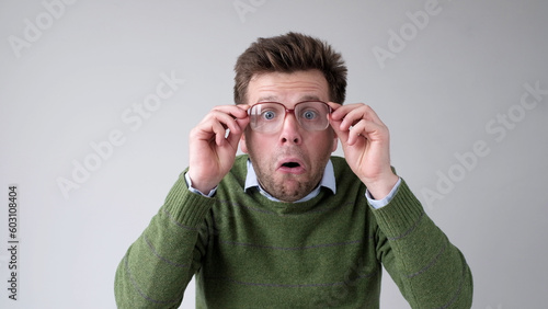 Cuadro en lienzo The European young man, in shock, covers his mouth with his hands, thinking, No, this is impossible