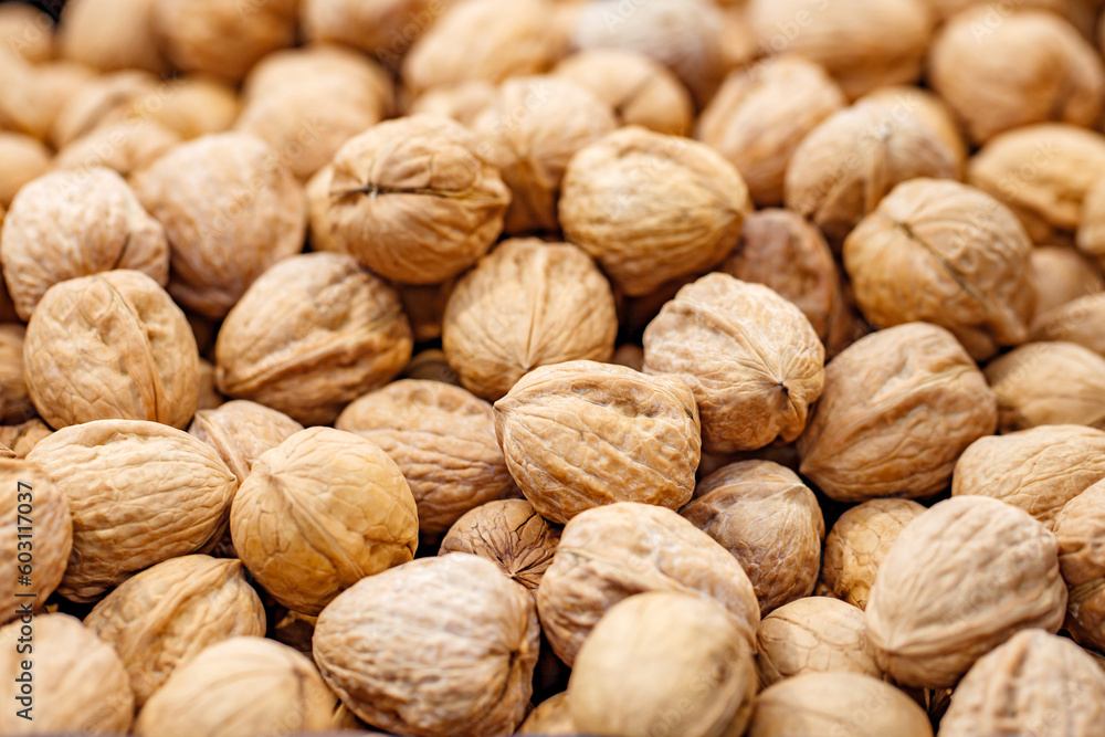 Walnuts unpeeled whole in bulk on market, selective focus Walnuts unpeeled whole in bulk on market, selective focus