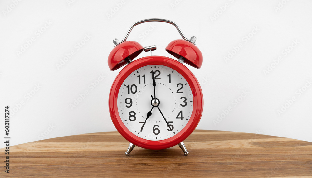 Red alarm clock on grey wall background Red alarm clock on grey wall background