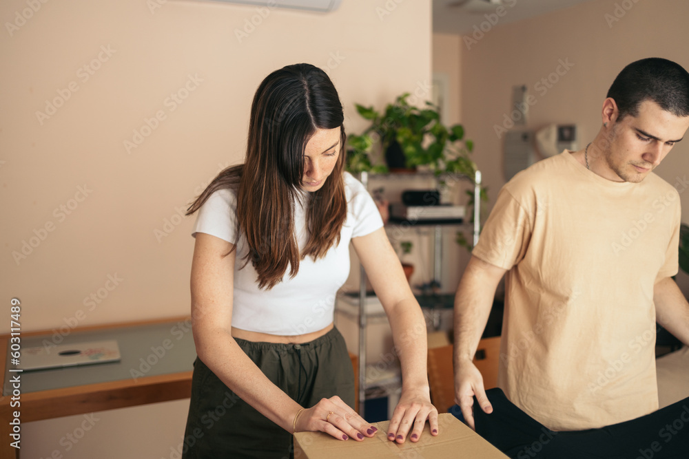Couple preparing the shipment of clothes from their online store Couple preparing the shipment of clothes from their online store
