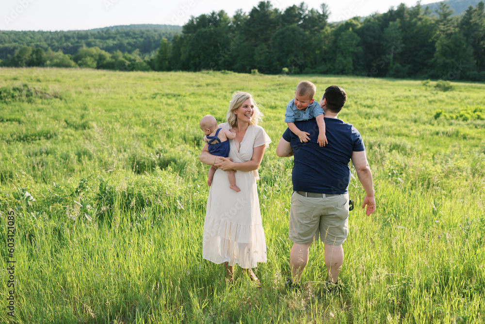Happy smiling family with baby and toddler outdoors in summer Happy smiling family with baby and toddler outdoors in summer
