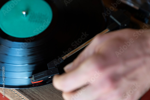 Close shot of a hand starting a record player photo