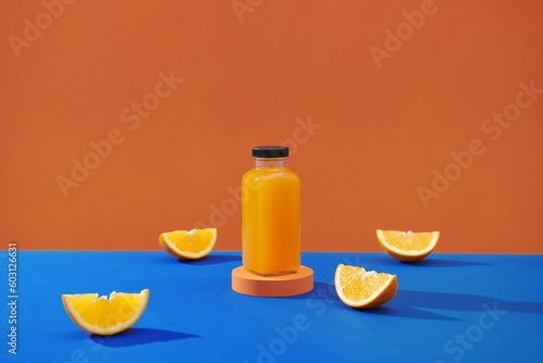 bottle of orange juice surrounded by oranges photo