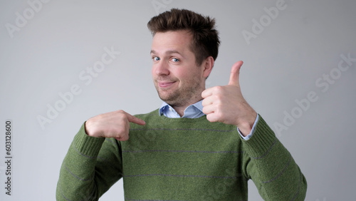 The European young man proudly points at himself, saying I am good with myself