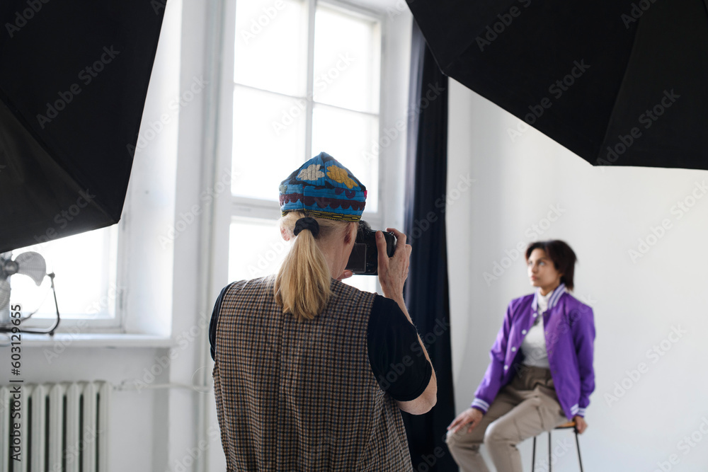 Female photographer shoots model in studio Female photographer shoots model in studio