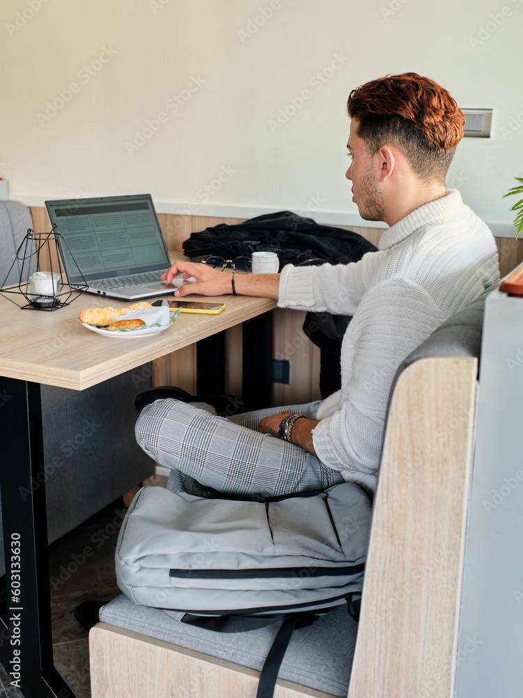 Young man using his laptop in a coffee shop Young man using his laptop in a coffee shop