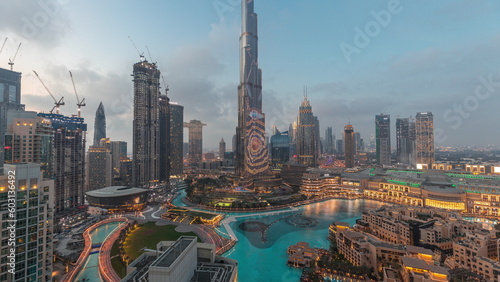 Skyscrapers rising above Dubai downtown day to night timelapse surrounded by modern buildings aerial top view