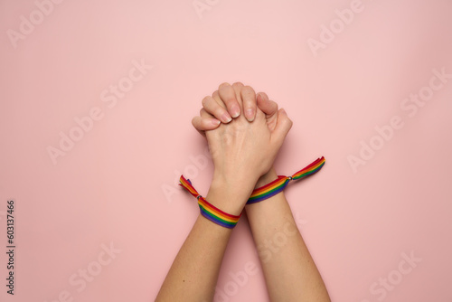 Intertwined hands of LGBT couple with gay community bracelets